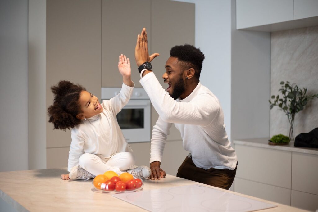 A father giving a high five to his young daughter