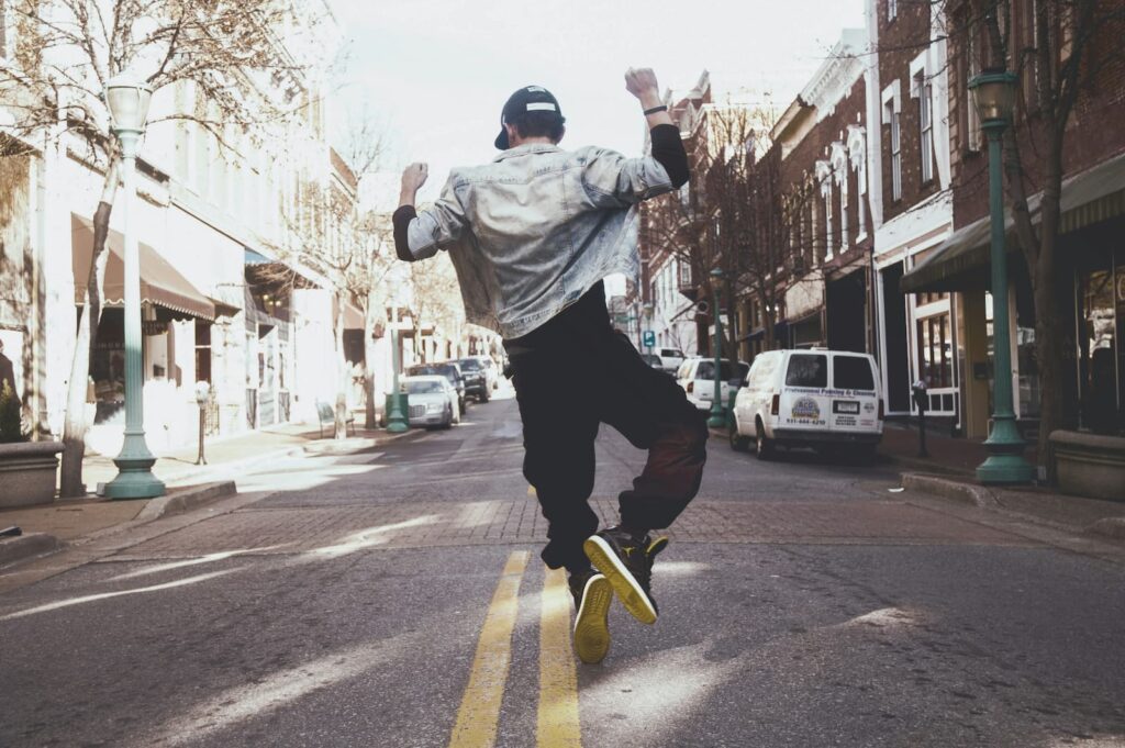 A man dancing in the middle of a narrow street