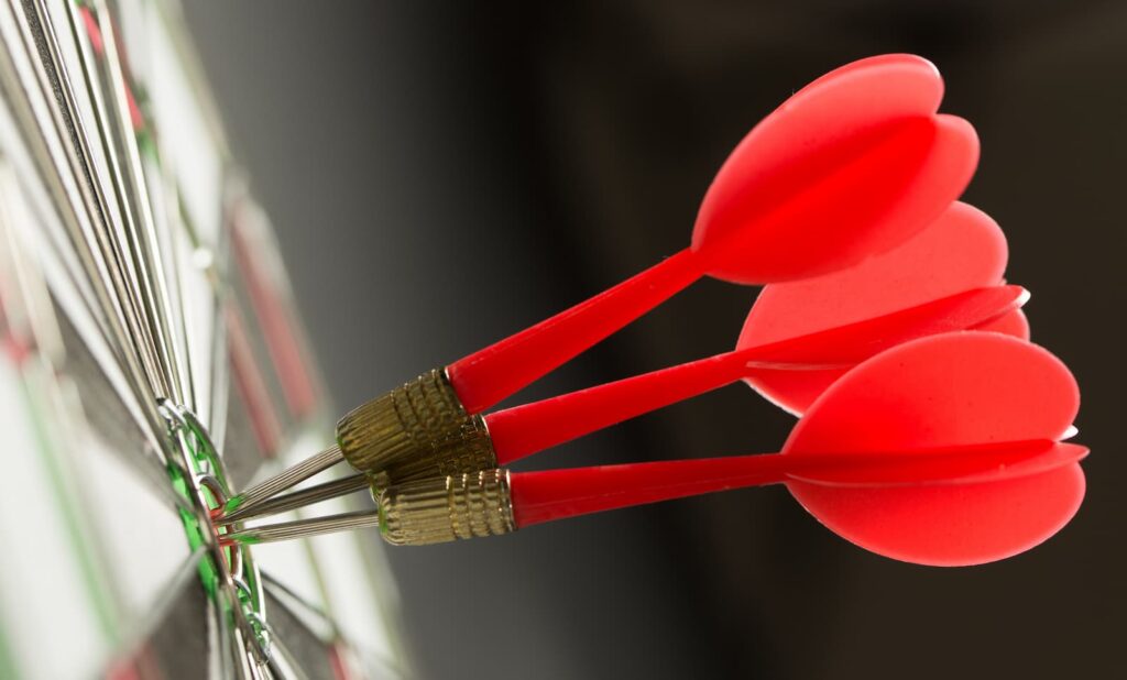 Three darts in the bullseye of a dartboard — consistency with unique selling points