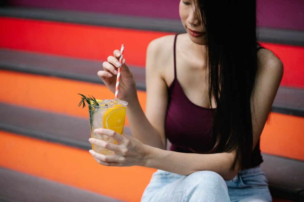 A woman holding a large glass of lemonade