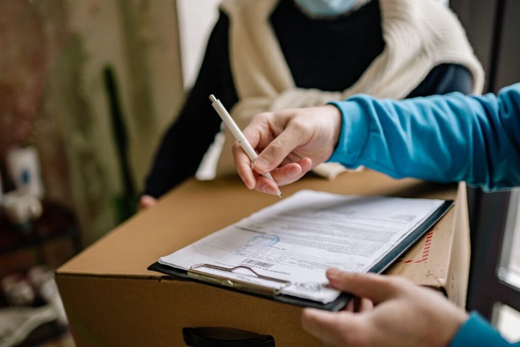 A person signing a document in order to receive a large delivery