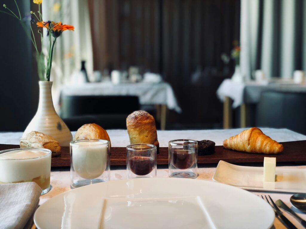 A thin tray with various kinds of bread on a table in an upscale dining room