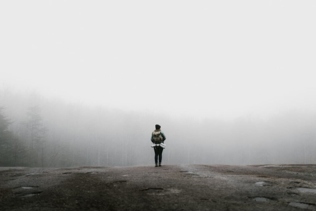 A woman standing in foggy forest