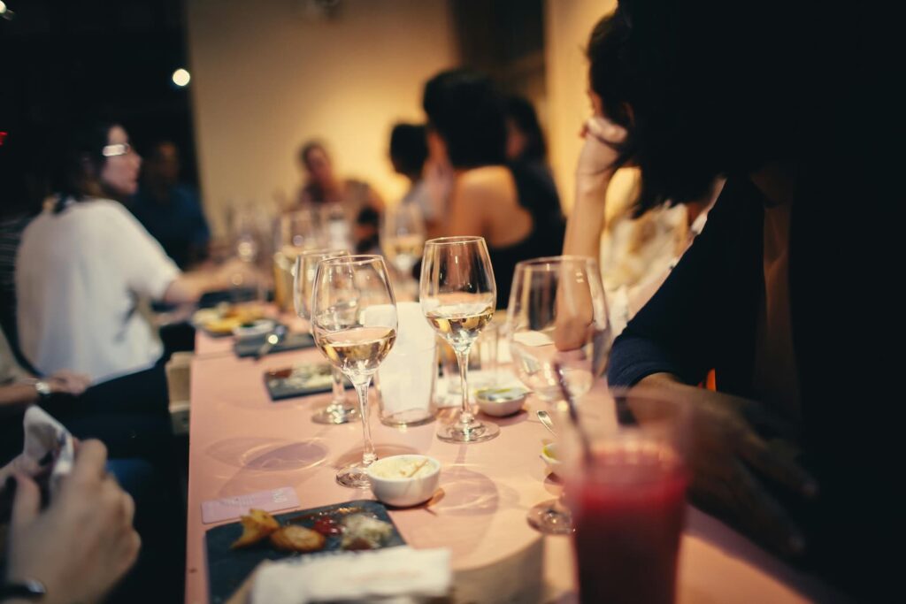 A long table with glasses of wine and small dishes of bite-sized foods