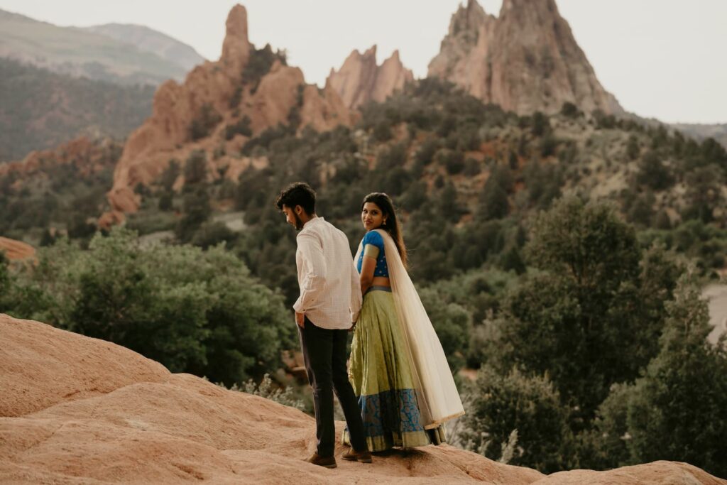A young couple walking outdoors with trees in the distance