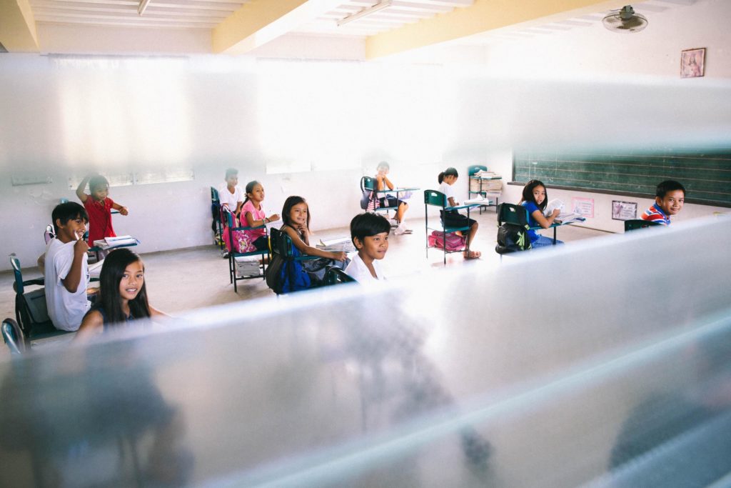 Kids sitting in a classroom in a school.