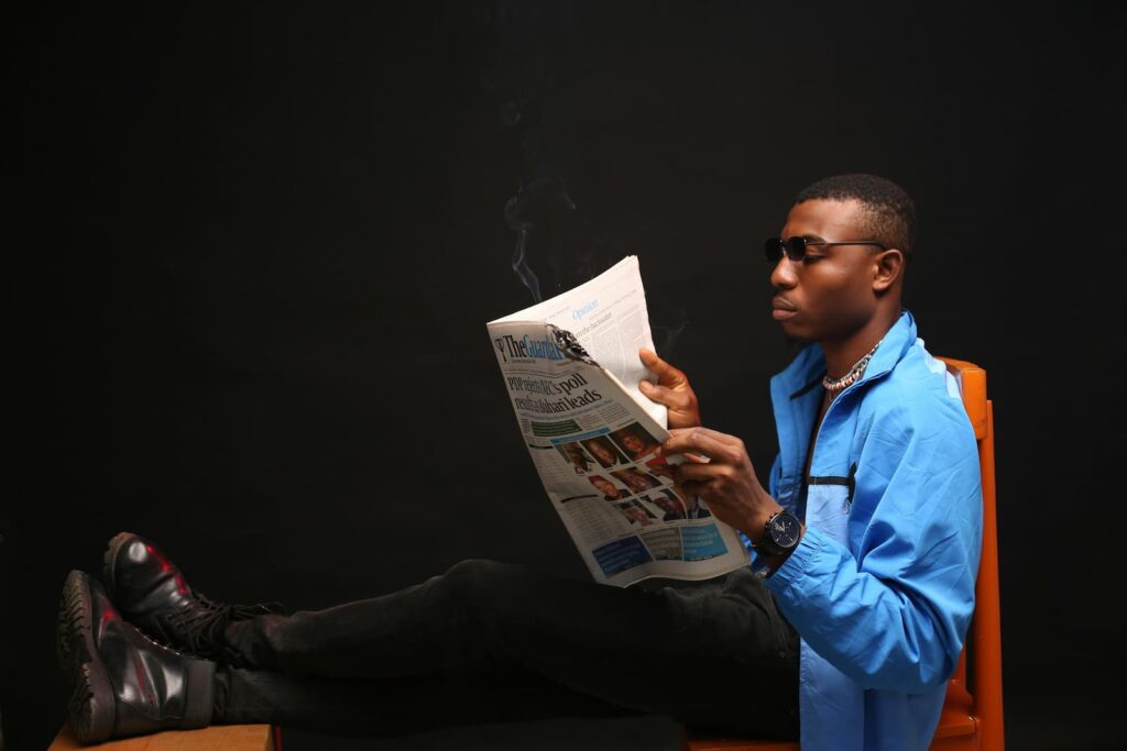 A seated man reading a newspaper