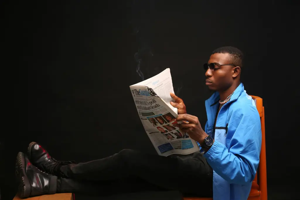 A seated man reading a newspaper