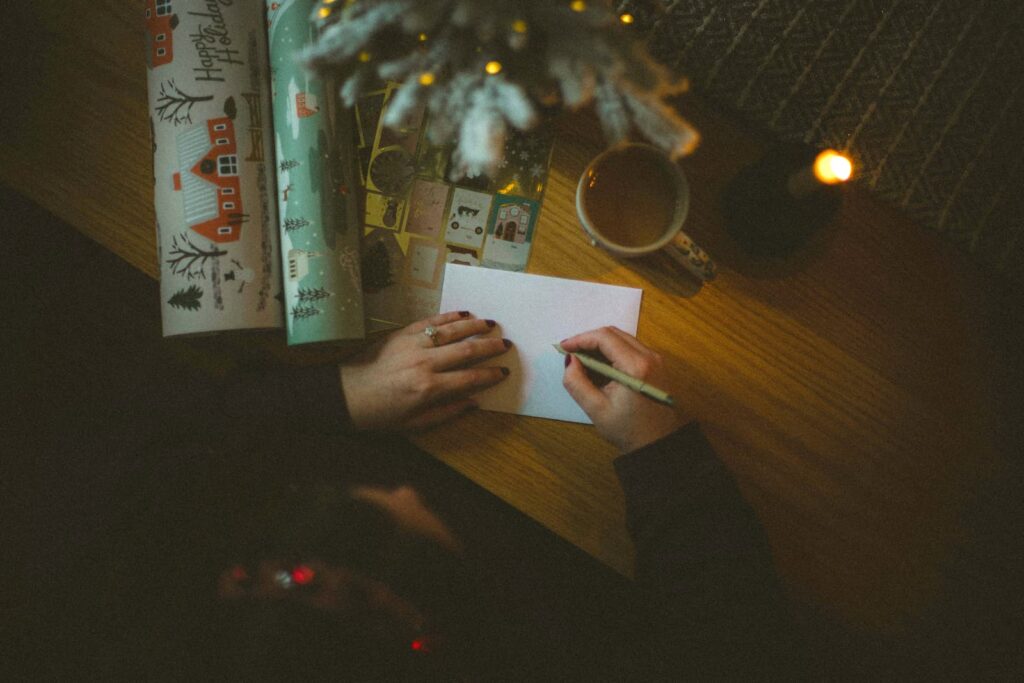 A woman writing on a greeting card envelope