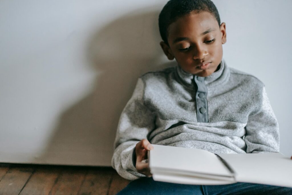 A bored male child holding a notebook
