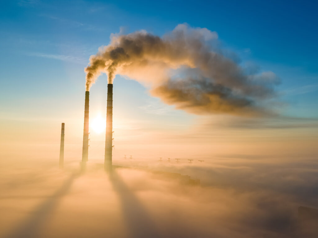 tall smokestacks releasing lots of gases into the air