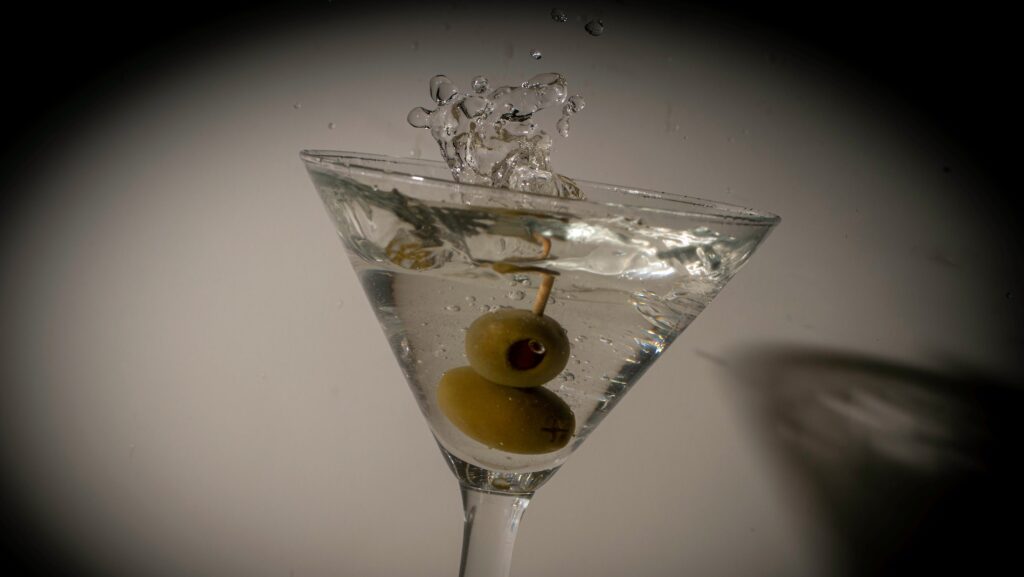 Olives dropping into a martini glass