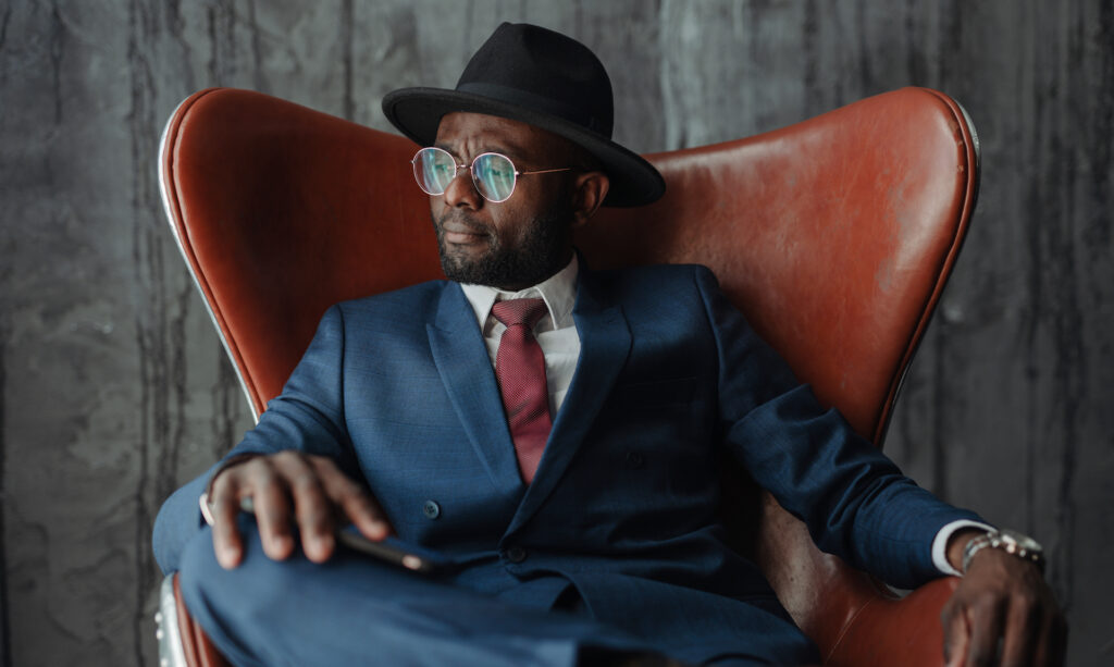 A man looking smart in a suit with glasses and a hat