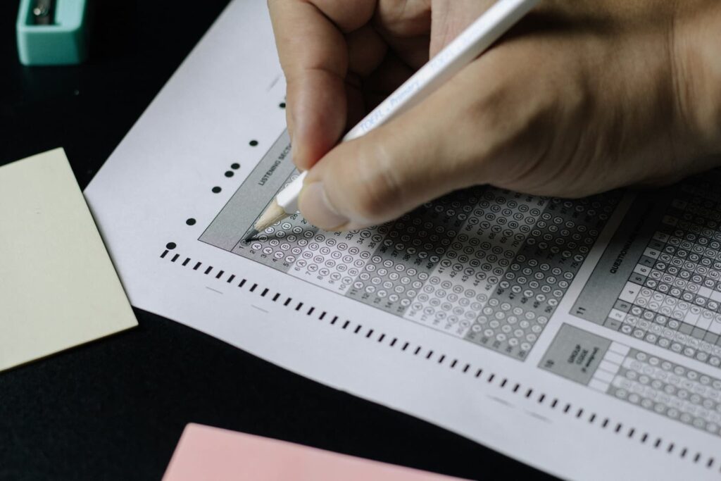 A person using a pencil to fill in answers on a standardized test sheet