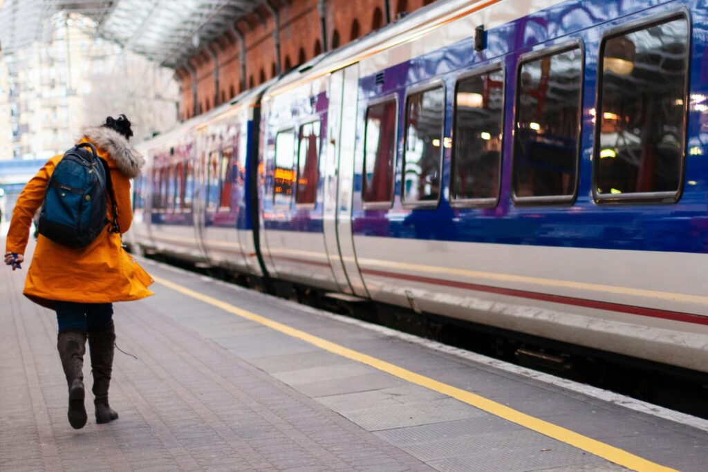 A woman standing a train platform as a train passes