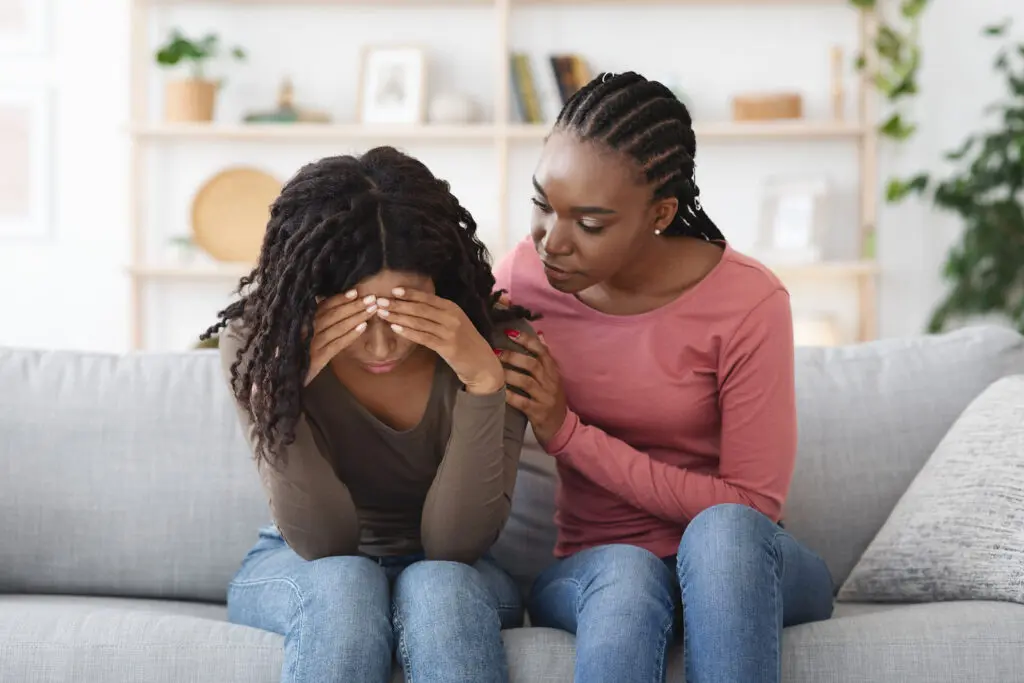 A young woman offering emotional support to her friend who is depressed