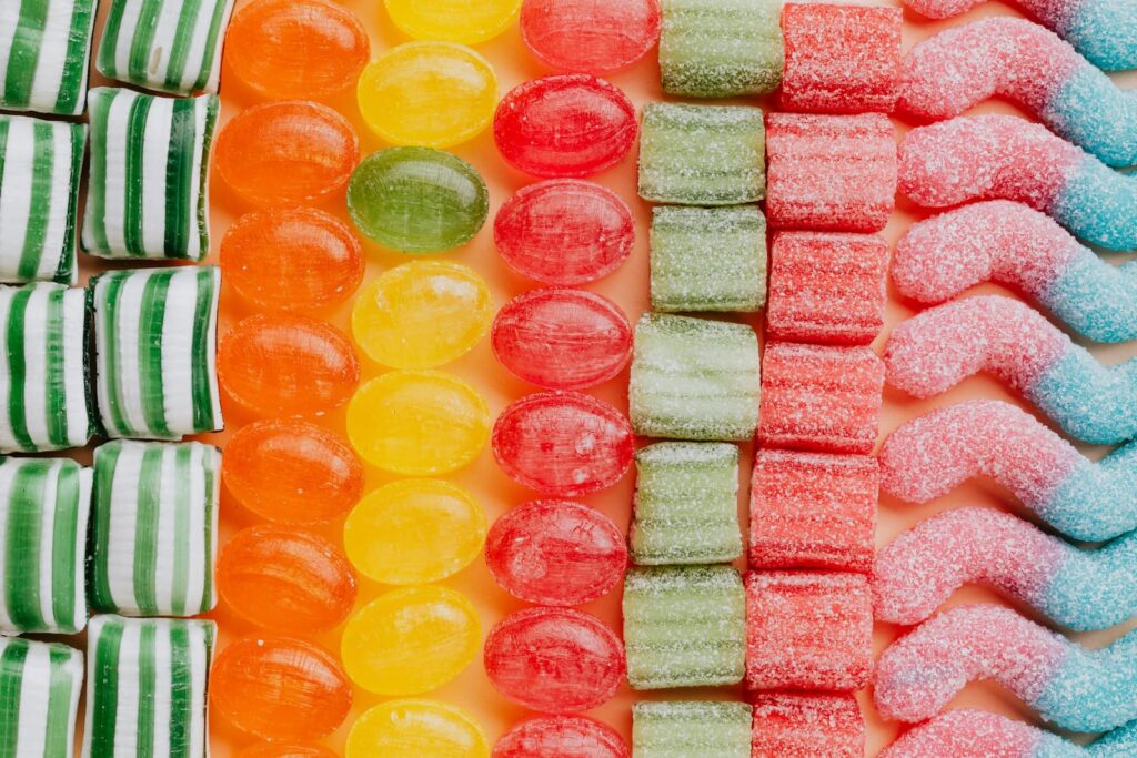 Various types of colorful candies arranged in neat rows