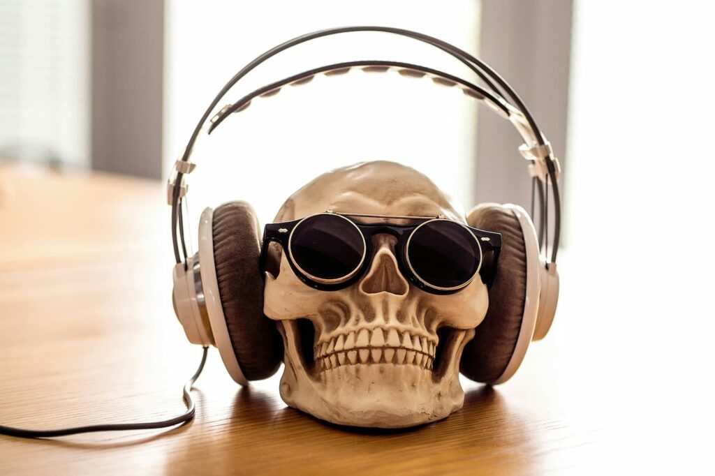 A skeleton's head wearing sunglasses and and large headphones