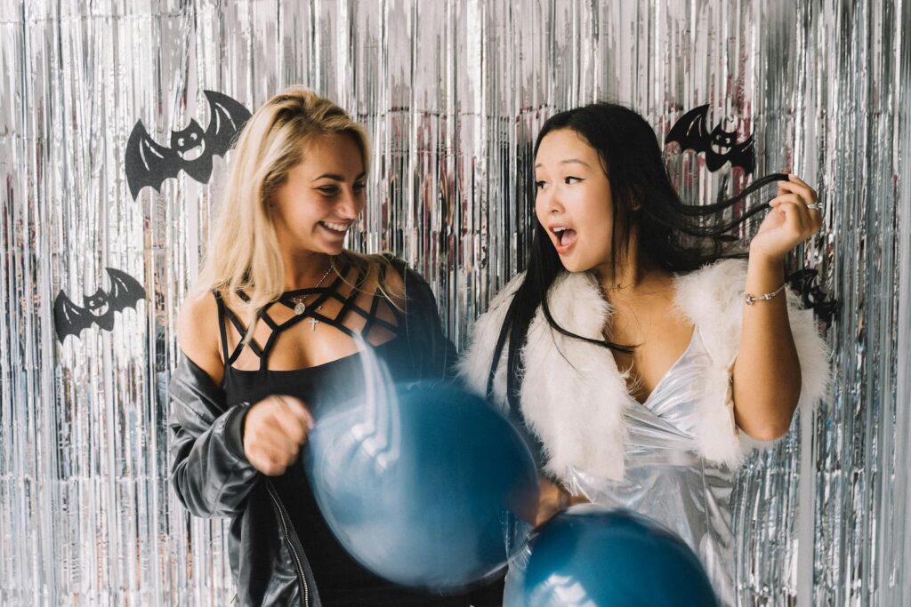 Two young women posing for a social media photo at a Halloween-themed party