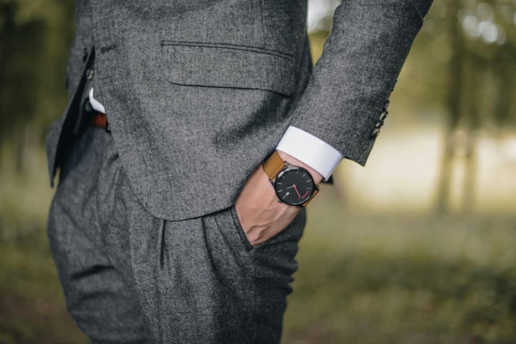 A man in a gray suit standing with his hands in his pockets