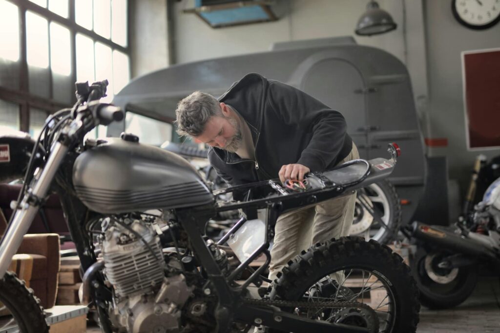 A man in a garage working on a motorcycle