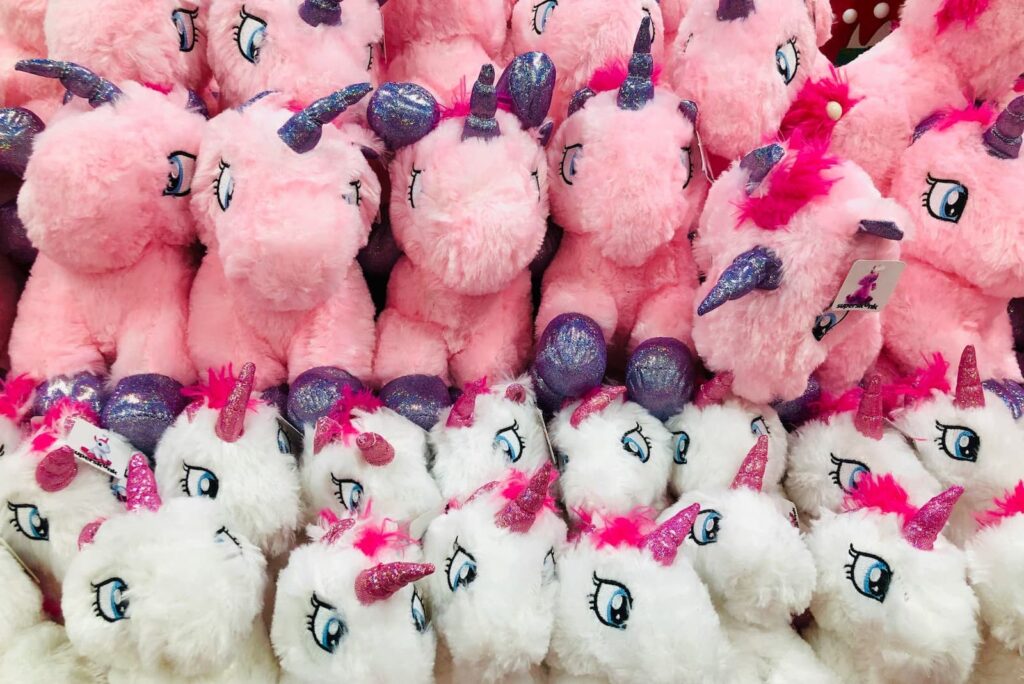 Pink and white plush toys shaped like unicorns