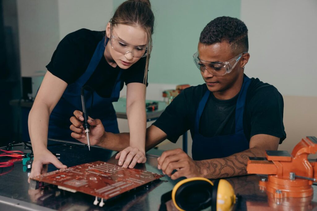 A woman and man working on a computer circuit board 