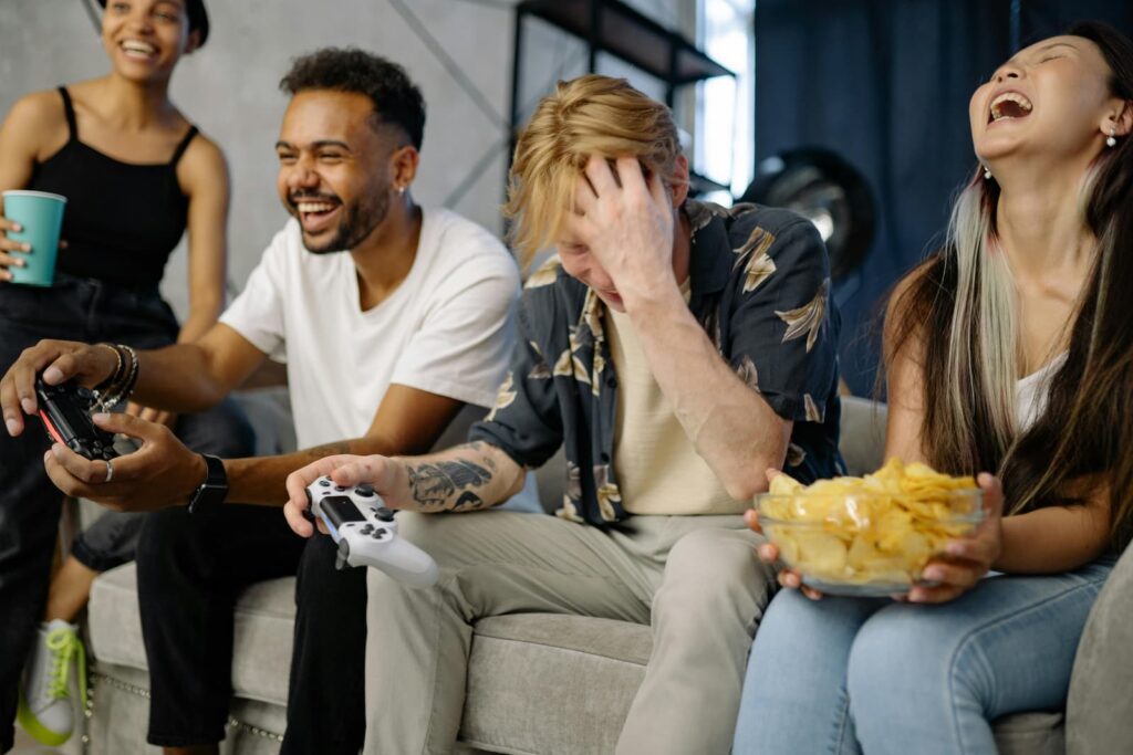Friends playing a video game while sitting on a sofa