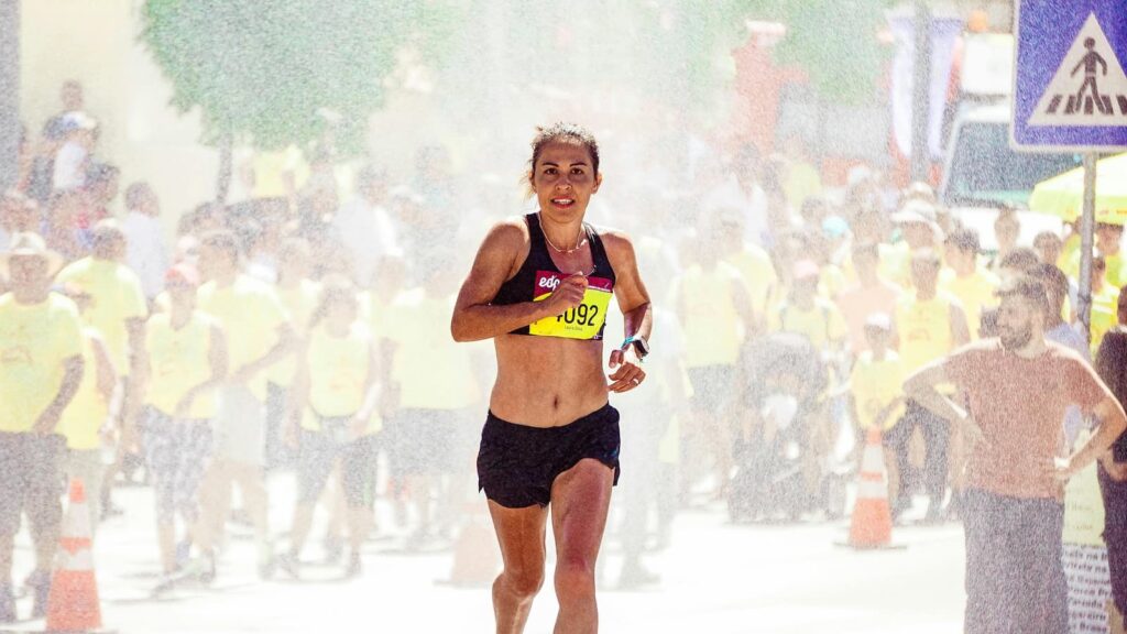 A woman running in a marathon on a hot day