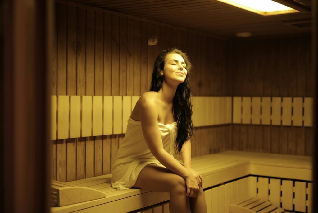 A woman in a towel enjoying a sauna by herself