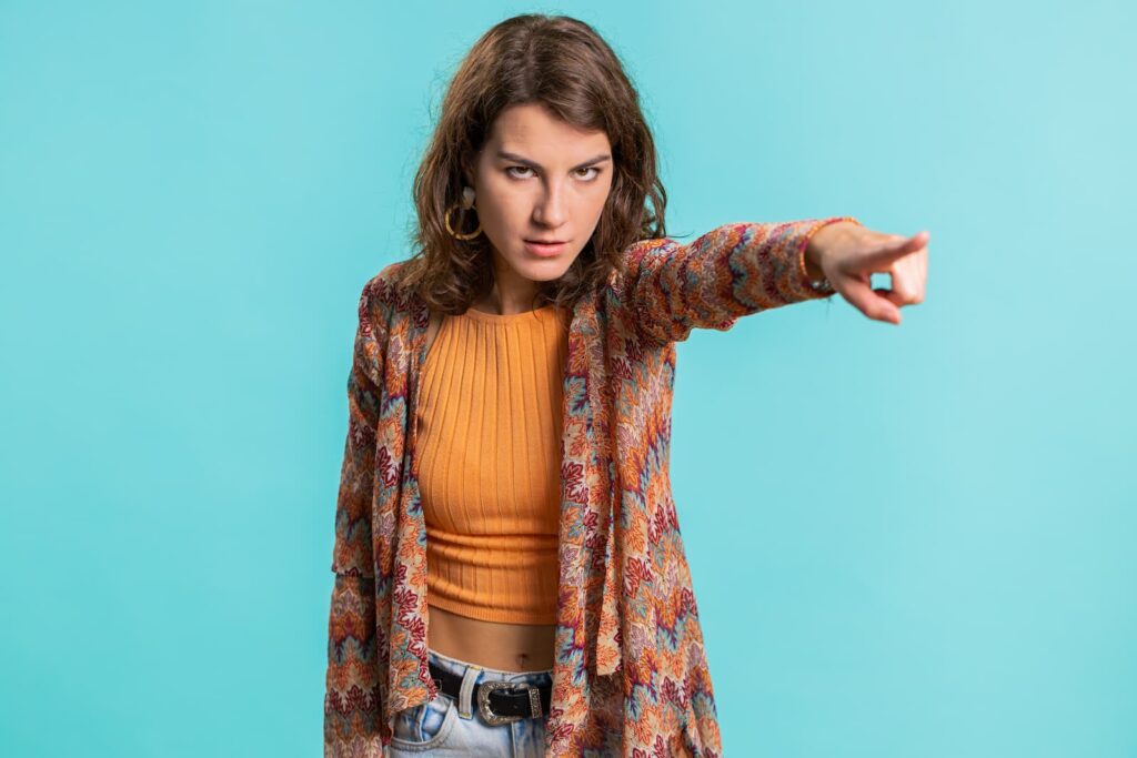 A serious woman gesturing for someone to go away
