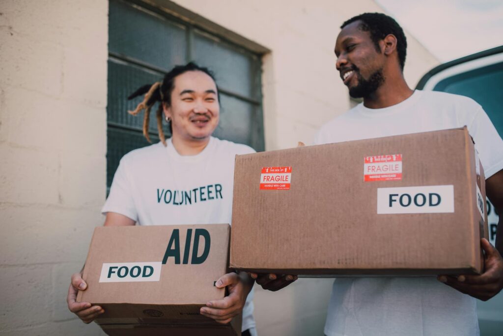 Two volunteers carrying boxes of food
