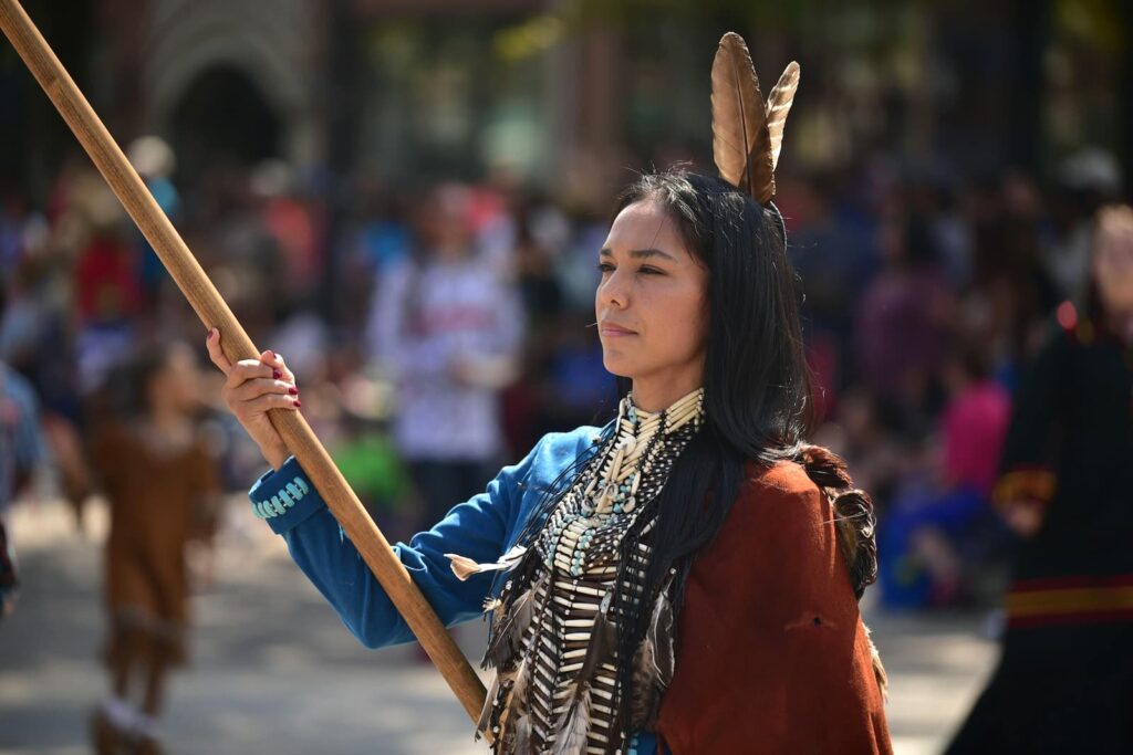 A woman standing in indigenous American clothing