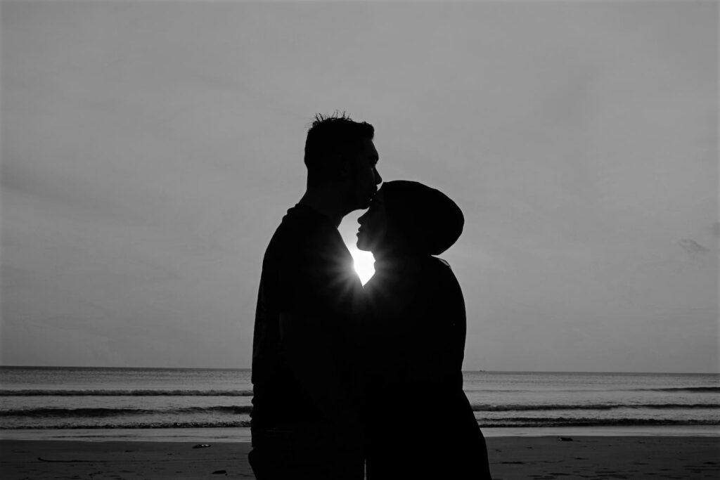 A silhouette of a couple embracing on a beach