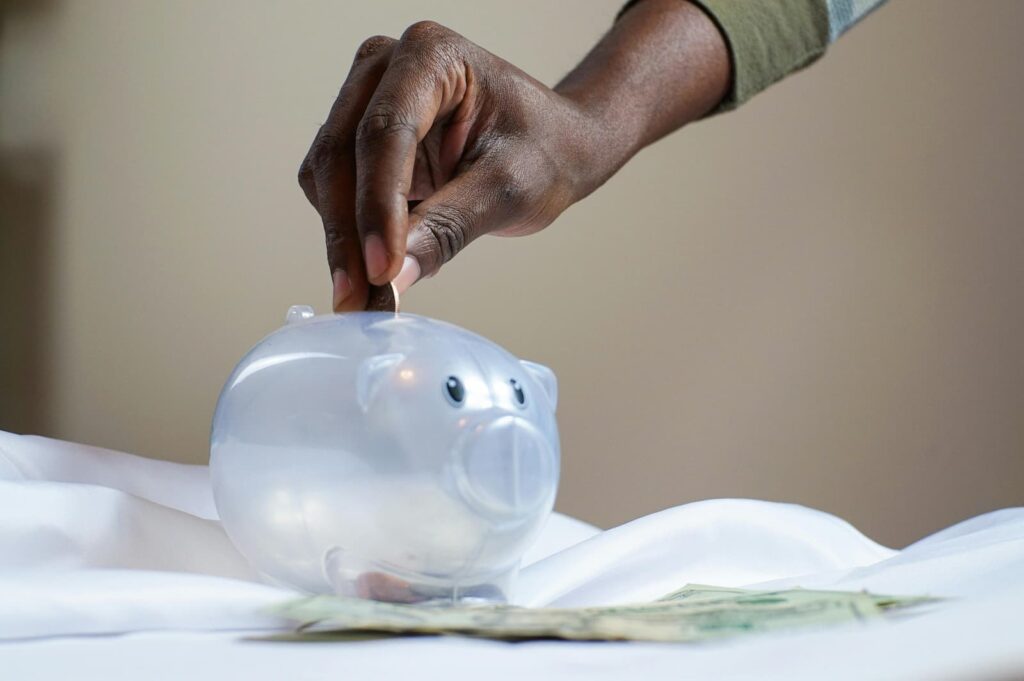 A man placing a coin into a piggy bank