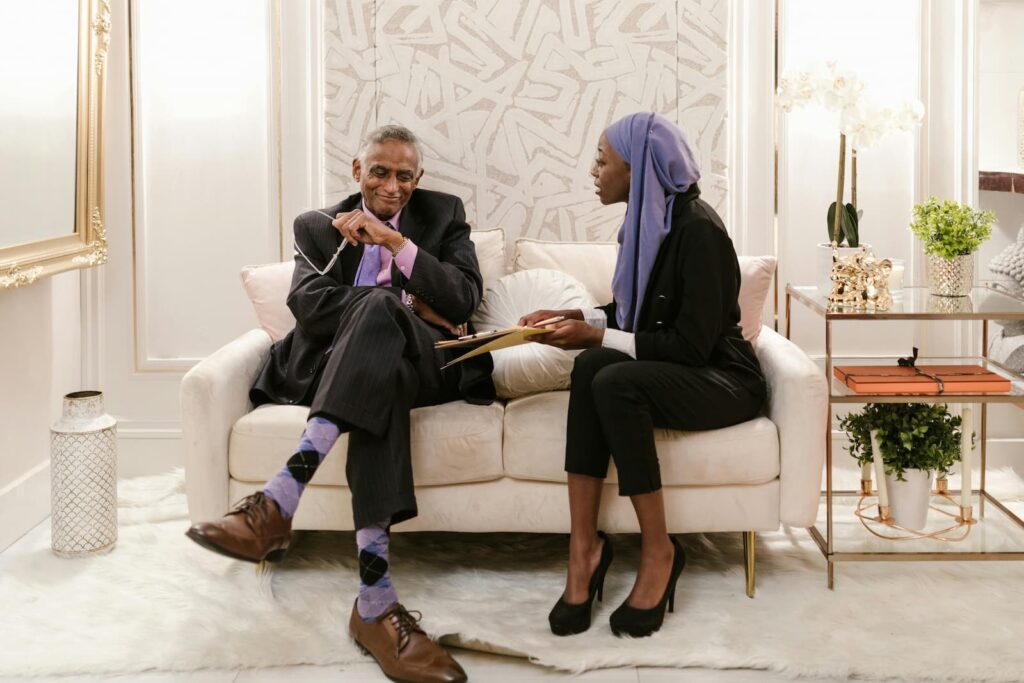 Two businesspeople negotiating while seated on a couch in a fancy room