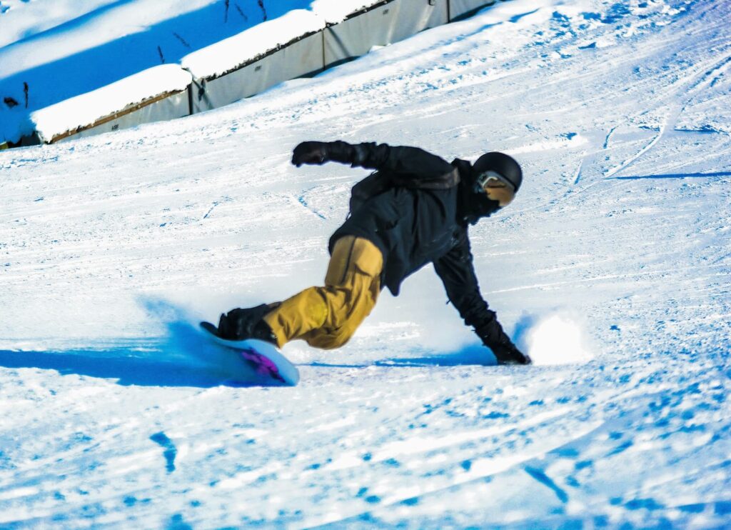 A snowboarding sliding down a hill