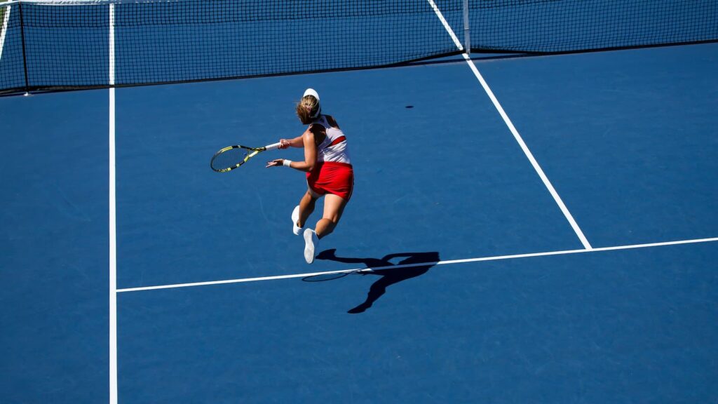 A tennis player swinging her racquet 