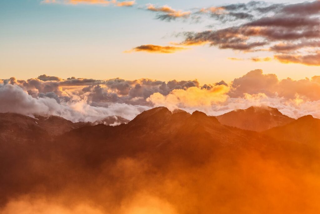 Mountain peaks among clouds in the sky