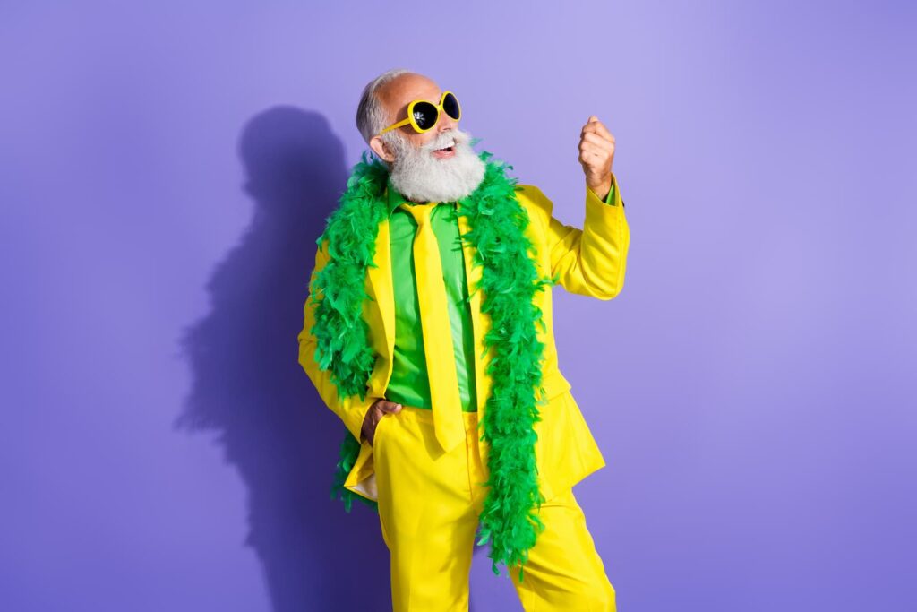 An eccentric older man in sunglasses and a bright yellow suit