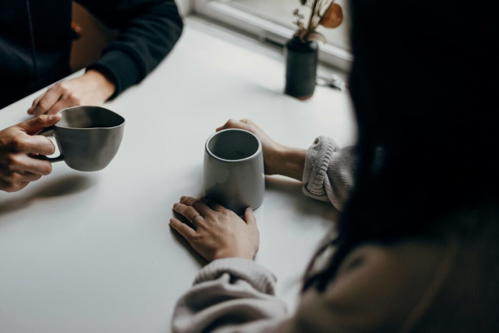 Two people chatting at a table with drinks