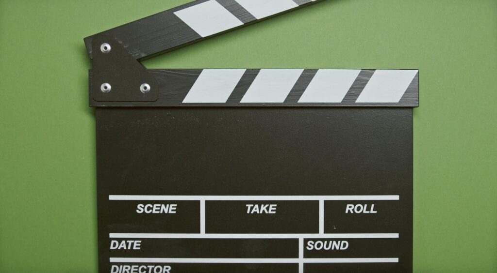 A film director's clapper board on a green background