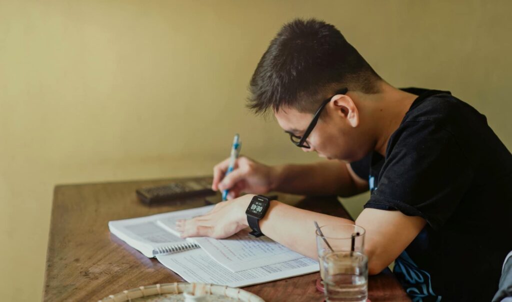 A man studying while seated at a wooden table